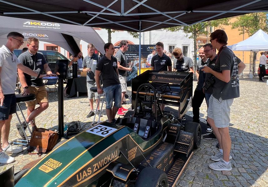 Fahrzeug Racing Team steht unter einem Pavillon auf dem Kornmarkt, um das Fahrzeug herum diskutieren Besucher und Teammitlgieder. 