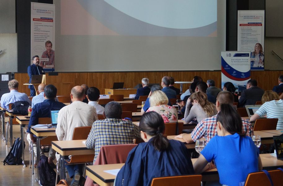 Foto: 14. Zwickauer Forum für Betriebswirtschaft, Geschäftsführender Direktor des IfB, Prof. Dr. habil. Dr. h. c. Bernd Zirkler, begrüßt die Teilnehmende in der Aula auf dem Campus Scheffelstraße (Quelle: IfB/Luise Langer) 