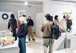 Personen stehen in einem Kunst-Laden und betrachten das Angebot.