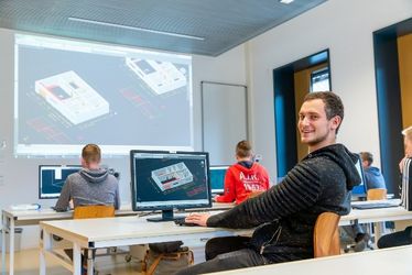 Mehrere Studierende sitzen an PC-Arbeitsplätzen, während an der Beamer-Leinwand ein Planungsbild gezeigt wird (Quelle: WHZ)