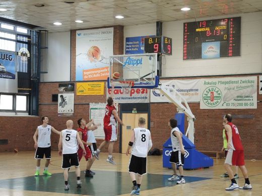 Foto: Basketballspieler während des Spieles in der Turnhalle.