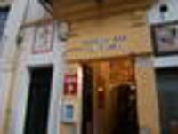 Foto: Eingangsbereich einer Bar mit der Schildaufschrift "Bodega Bar El Pimpi".