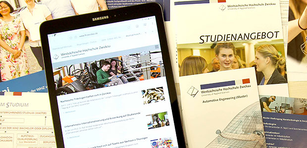 Foto: Titelbild Neuigkeiten und Informationen. Ein Tablet liegt auf einem Tisch mit geöffneter Webseite. Ringsherum liegen Flyer zum Studienangebot.