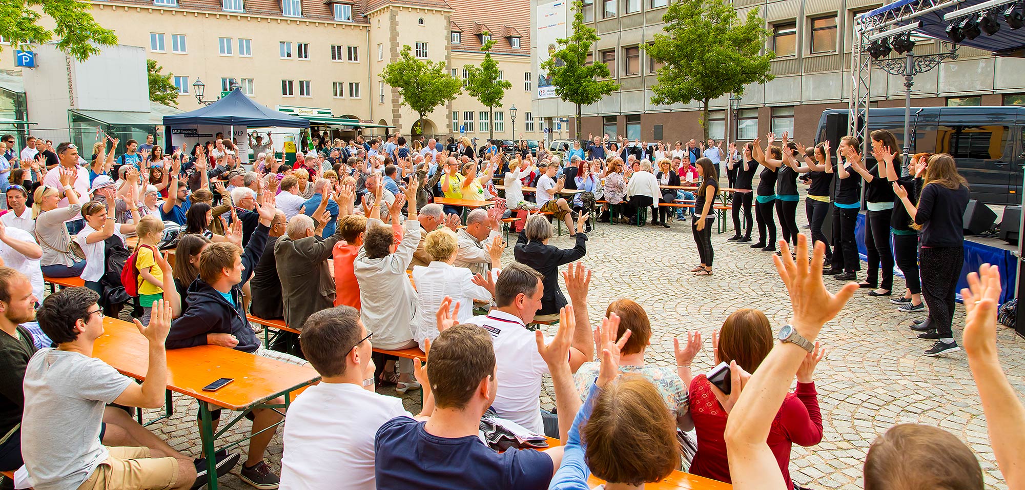 Foto: Titelbild Services für Alumni. Teilnehmer der Alumni-Veranstaltung sind auf dem Kornmarkt versammelt und werden durch ein Bühnenprogramm unterhalten.