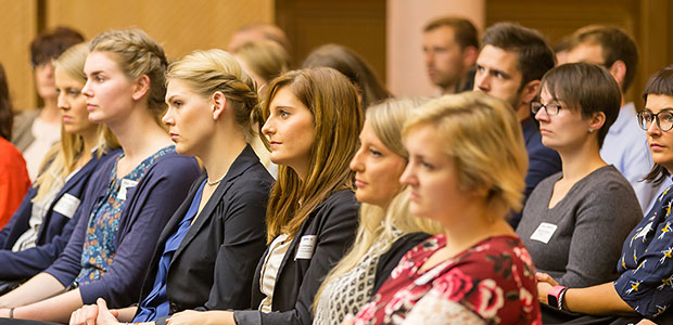 Foto: Titelbild Spenden und Fördern. Teilnehmer sitzen in einer Veranstaltung und blicken in eine Richtung.