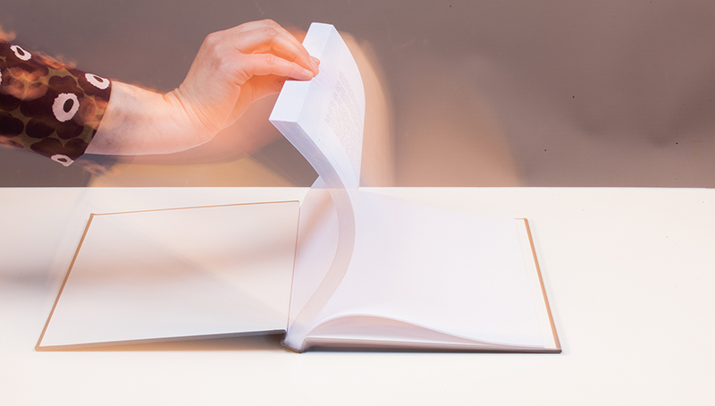Foto: Person schlägt ein Buch auf