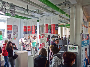 Foto: Studierende bei der Messe schauen sich die ausgestellten Stücke an.