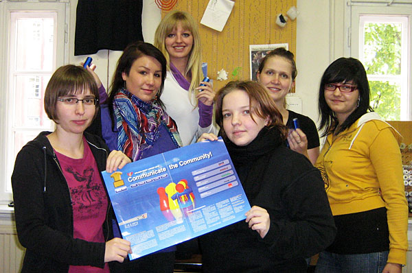 Gruppenfoto: Unsere Studenten die sich am Golden Shirt Award 2012 beteiligten. Sie halten ein Werbeplakat mit dem Titel "Communicate the Community" in die Kamera.