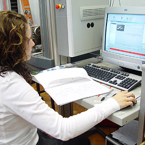 Foto: Eine Studierende sitzt vor einem Computer im Prüflabor und ließt Werte vom Bildschirm ab.