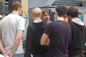 Foto: Eine Gruppe Studierender erhält von einem Lehrbeauftragten eine Unterweisung im Labor.