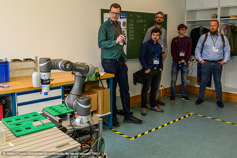 Foto: Ein Roboter und Zuschauende zum Workshop an der Hochschule MIttweida