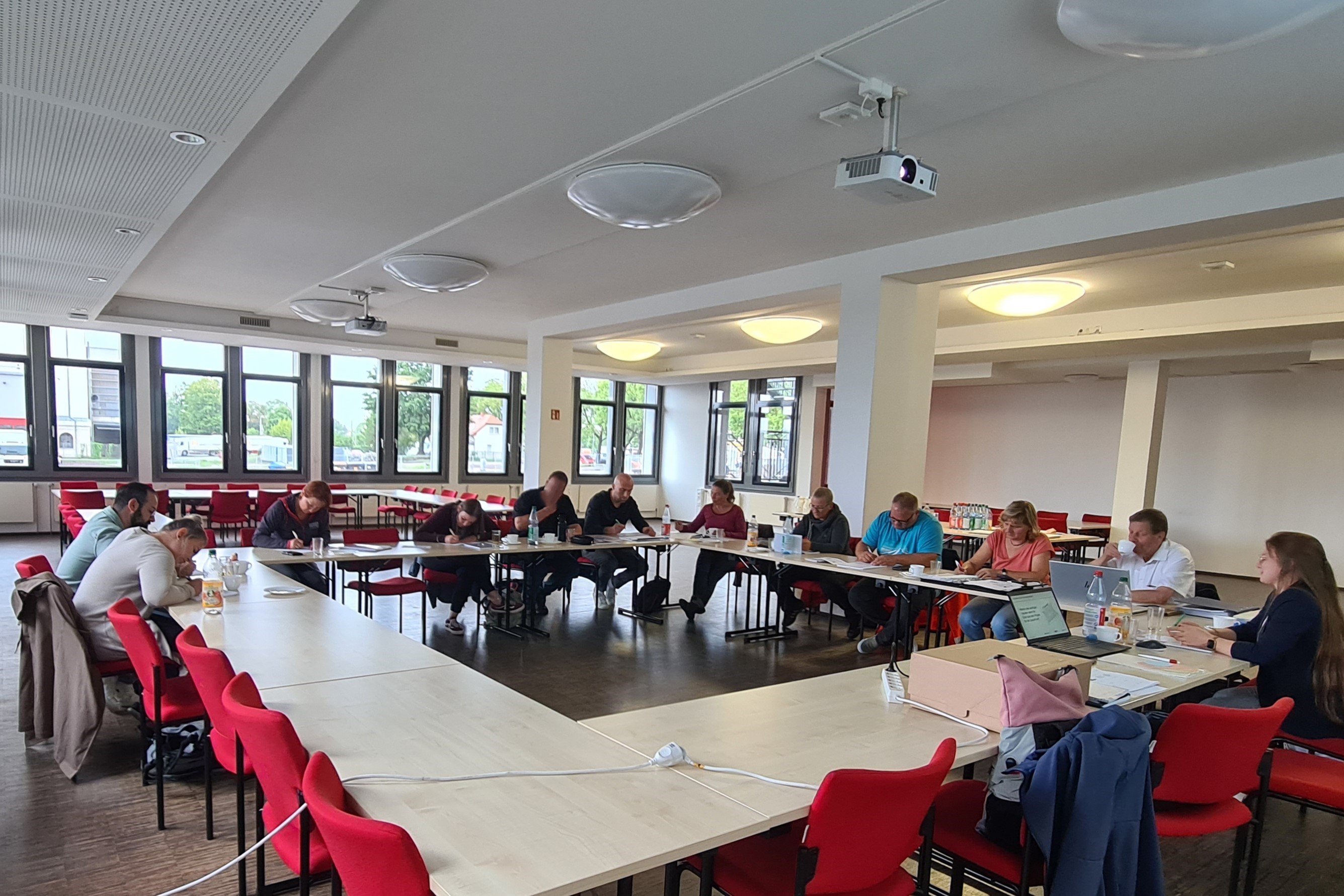 Foto: Abschlussworkshop der 3.Phase des TEK-Forschungsprojektes, DRK Landesverband Dresden, Teilnehmer sitzen in großer Runde und hören einem Vortrag zu 