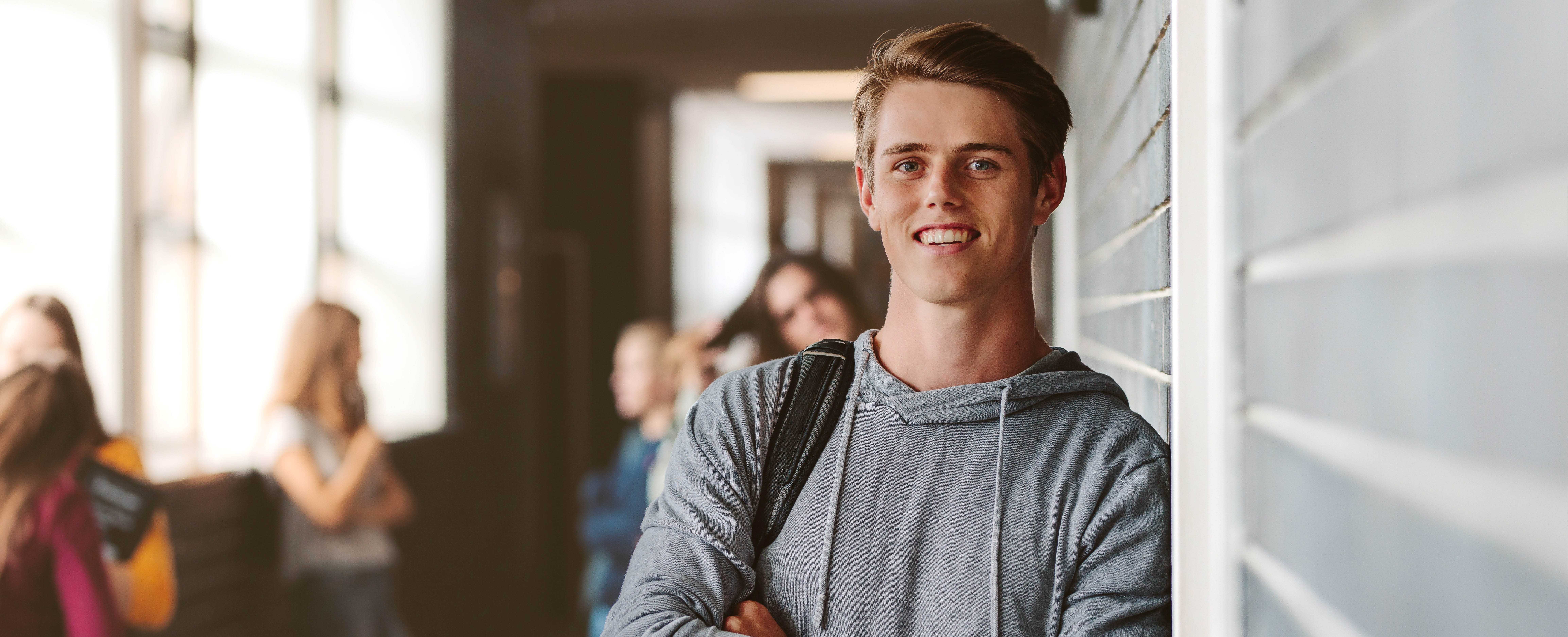 Lächelnder Student in einer Hochschule (Quelle: AdobeStock/Jacob Lund)