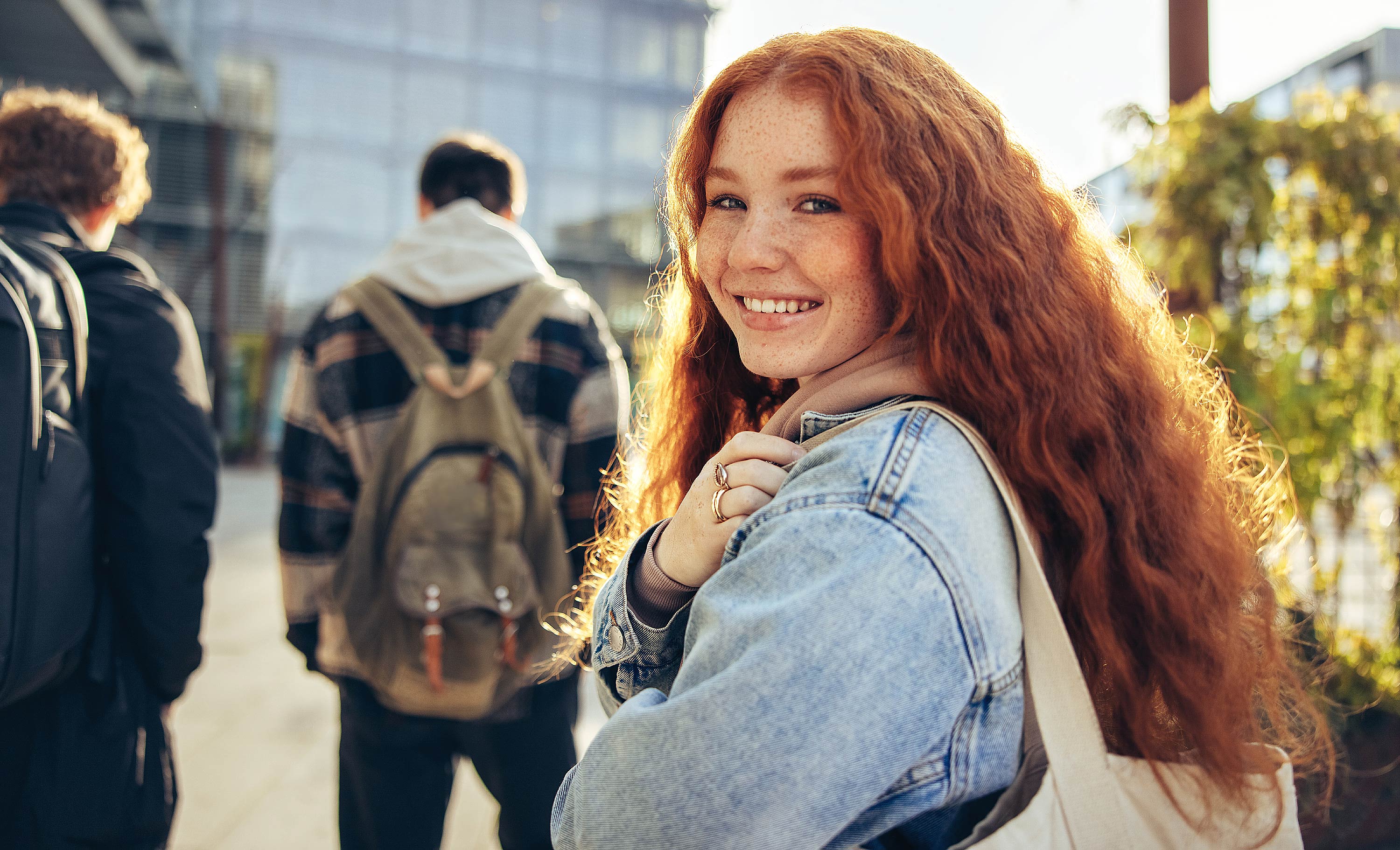 Studentin läuft über Campus und schaut über ihre Schulter (Quelle: AdobeStock/Jacob Lund)