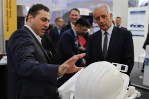 WHZ-Professor Rigo Herold erklärt dem sächsischen Ministerpräsidenten Stanislaw Tillich am CeBIT-Stand den Augmented-Reality-Schutzhelm.