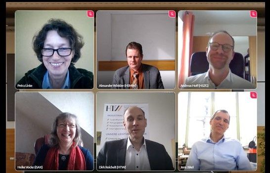 Foto: In 2 Reihen sind jeweils 3 Personen nebeneinander zu sehen, sie sind alle einer virtuellen Konferenz zugeschalten. 