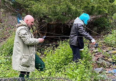 Ein Mann und eine Frau in herbstlichen Outfits in einem Waldgelände