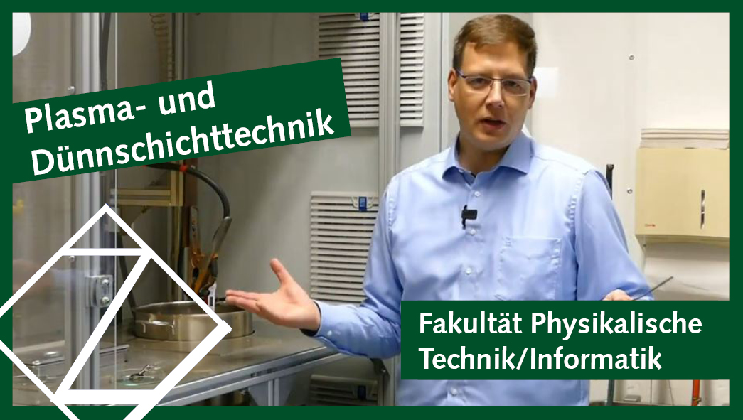 Prof. Mike Fröhlich steht in einem Physik-Labor und spricht in die Kamera