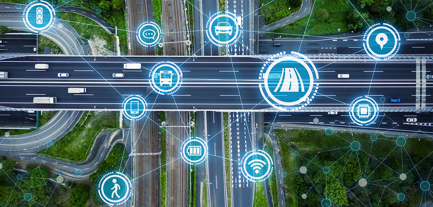 Eine Kreuzung von Straßen- und Bahnlinien aus der Vogelperspektive, im Vordergrund grafische Elemente zum Thema Verkehr und Digitalisierung 